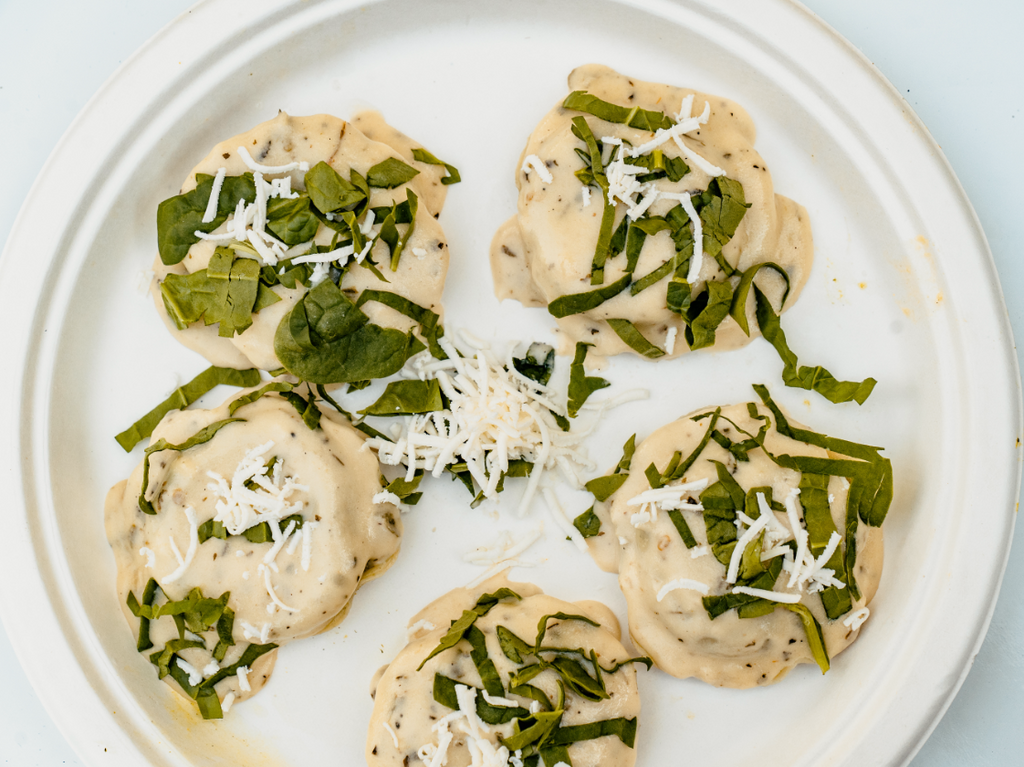 Spinach and paneer stuffed raviolis topped with a creamy alfredo and garlic sauce 